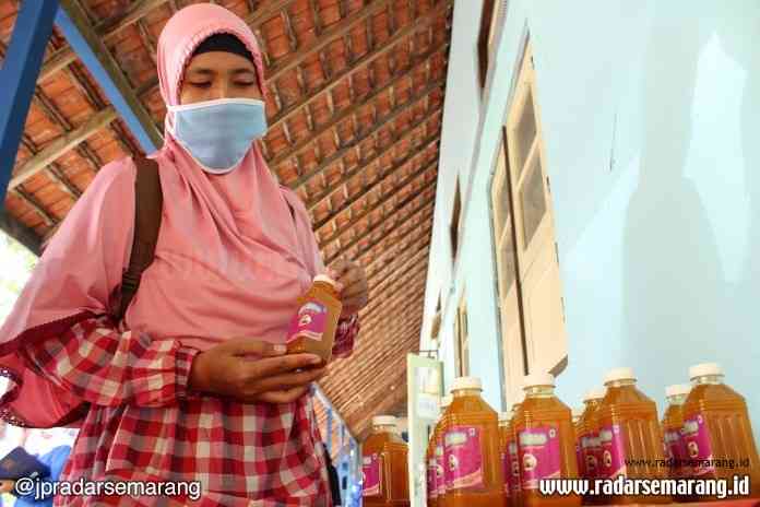 Guru SMK Muhammadiyah Magelang memberikan minuman herbal kepada orang tua sebelum memasuki ruangan untuk mengikuti pembagian rapor. (Puput Puspitasari/Jawa Pos Radar Semarang)