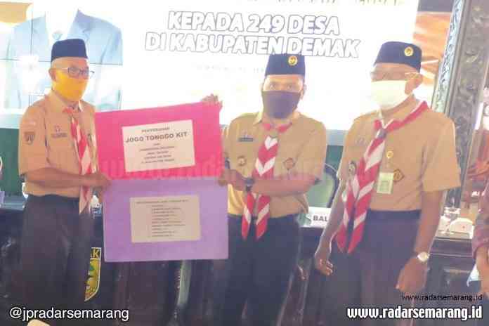 Bupati Demak HM Natsir menyerahkan bantuan Jogo Tonggo Kit untuk desa dan kelurahan di Demak. (Wahib Pribadi/Jawa Pos Radar Semarang)