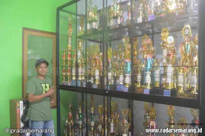 Wahyudi, maestro merpati Raja Besi Magelang bersama ratusan piala kemenangan. (Agus Hadianto/Jawa Pos Radar Semarang)