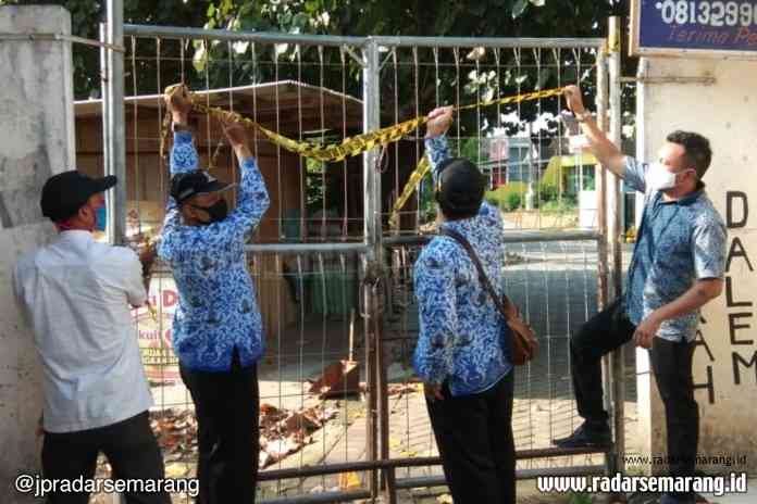 Sejumlah petugas membuka kembali pita segel Pasar Meteseh. Kamis (18/6/2020) ini pasar yang berlokasi di Kecamatan Tembalang itu akan beroperasi kembali. (Norma Sari Yulianingrum/Jawa Pos Radar Semarang)