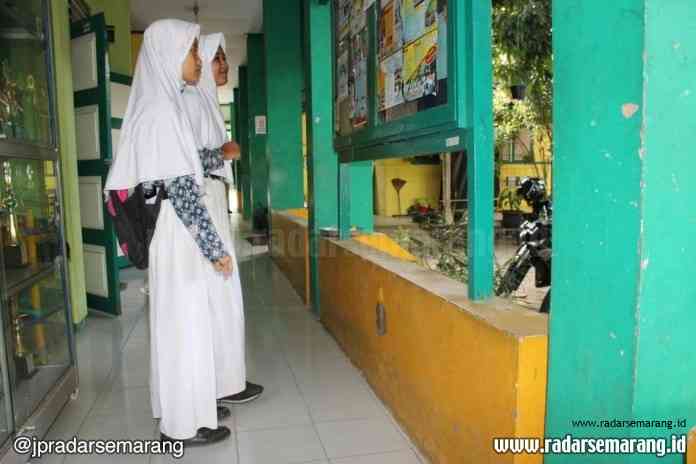 Siswa SMP di Kota Pekalongan menengok papan mading untuk menanti pengumuman PPDB. (Norma Sari Yulianingrum/Jawa Pos Radar Semarang)