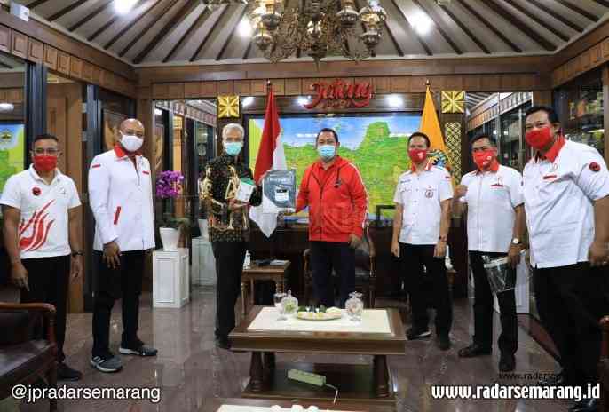 Ketua Taruna Merah Putih (TMP) Jawa Tengah Hendrar Prihadi saat memberikan bantuan secara simbolis kepada Gubernur Jawa Tengah Ganjar Pranowo. (Istimewa)