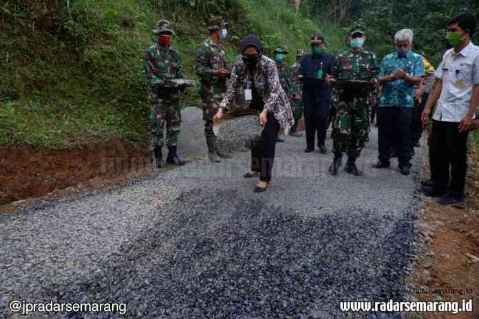 Sekda Kabupaten Pekalongan Mukaromah Syakoer bersama TNI sedang menabur kerikil dalam pembukaan TMMD Sengkuyung Tahap II di Desa Tlogopakis, Petungkriyono Selasa (30/6/2020). (Anang Rendi Ahmad/Jawa Pos Radar Semarang)