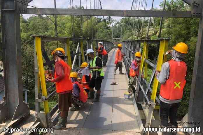 Warga saat melakukan pengecatan jembatan gantung Soropadan dan Parakan (30/6/2020). (Istimewa)