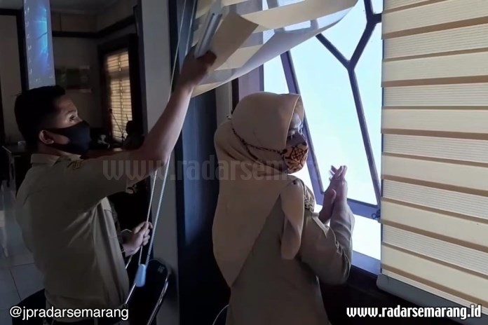 Pegawai Pemerintahan Kabupaten Pekalongan sedang membuka jendela sebelum rapat EPPD dimulai, di aula Setda Kabupaten Pekalongan, Senin (27/7/2020). (Nanang Rendi Ahmad/Jawa Pos Radar Semarang)