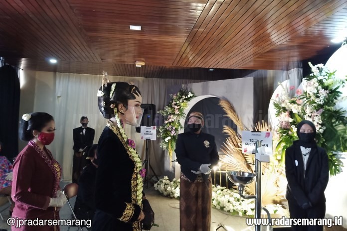 Model pengantin perempuan tetap terlihat cantik meski harus mengenakan pelindung wajah. (Puput Puspitasari/Jawa Pos Radar Semarang)