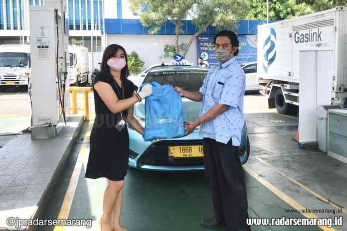 Area Head Surabaya PT Gagas Energi Indonesia Miranti Dyah Pramesti menyerahkan bantuan paket sembako kepada pengemudi taksi Blue Bird di Surabaya. (Istimewa)