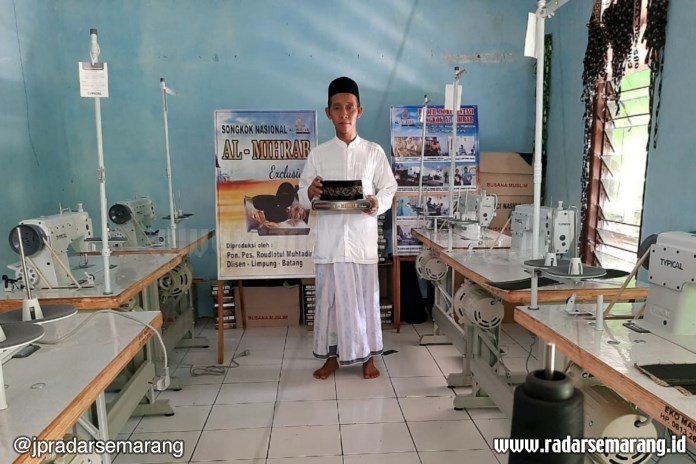 Pengasuh Ponpes Raudlotul Muhtadin, Khabib Ghozi menunjukkan peci buatan santrinya. (Riyan Fadli/Jawa Pos Radar Semarang)