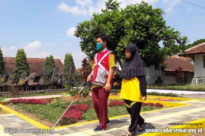 Salah seorang penyandang disabilitas saat menggunakan rompi dan tongkat sensorik Penganthi. (Tabah Riyadi / Jawa Pos Radar Kedu)