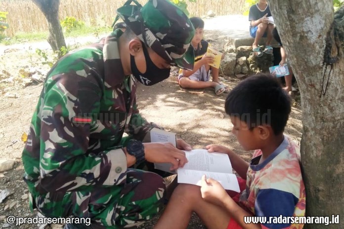 Tim Satgas TMMD Reguler ke-108 Desa Tambakselo Kecamatan Wirosari, Grobogan mengajak anak-anak rajin membaca. (Intan Maylani Sabrina/Jawa Pos Radar Kudus)