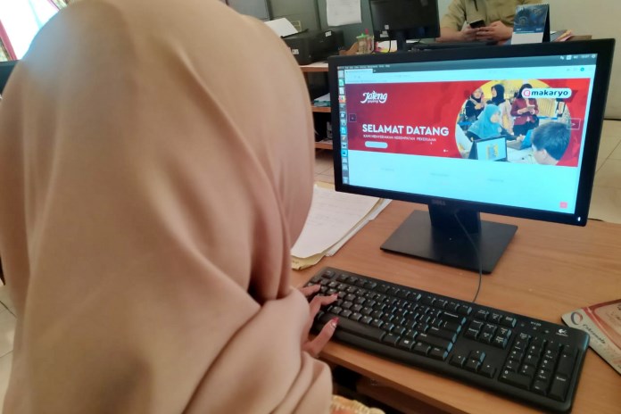 Pegawai Dinperinaker menunjukkan laman e Makaryo, untuk mencari kerja dan pekerja, saat ditemui di kantornya, Senin (24/8/2020). (Lutfi Hanafi/Jawa Pos Radar Semarang)