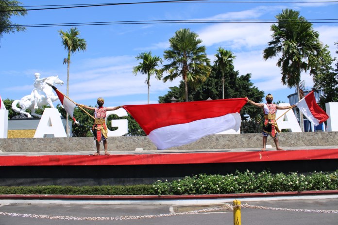 Anggota komunitas Sigrak Bawono Team membentangkan bendera merah putih di Alun-alun Kota Magelang Senin (17/8/2020). (Puput Puspitasari/Jawa Pos Radar Semarang)
