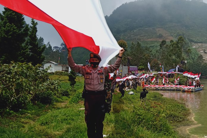 Ratusan personel gabungan, Polri, TNI dan masyarakat membantangkan bendera sepanjang Desa Sembungan, Kecamatan Kajajar, Wonosobo. (Sigit Rahmanto/Jawa Pos Radar Semarang)