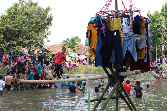 Suasana lomba meniti pinang di Kali Pegaden Tengah, Kecamatan Wonopringgo, Rabu (19/8/2020). (Nanang Rendi Ahmad/Jawa Pos Radar)