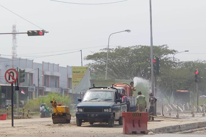 Petugas sedang melakukan pengecoran di Jalan Arteri Pelabuhan KM 4+150, Selasa (18/8/2020). (Dewi Akmalah/Jawa Pos Radar Semarang)