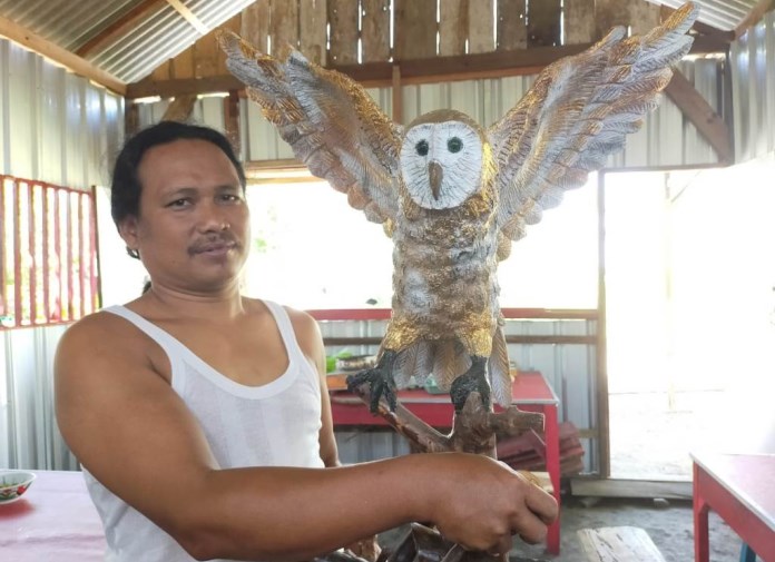 Mukhlisin menunjukkan karya seninya membuat replika burung hantu Tyto Alba. (Wahib Pribadi/Jawa Pos Radar Semarang)