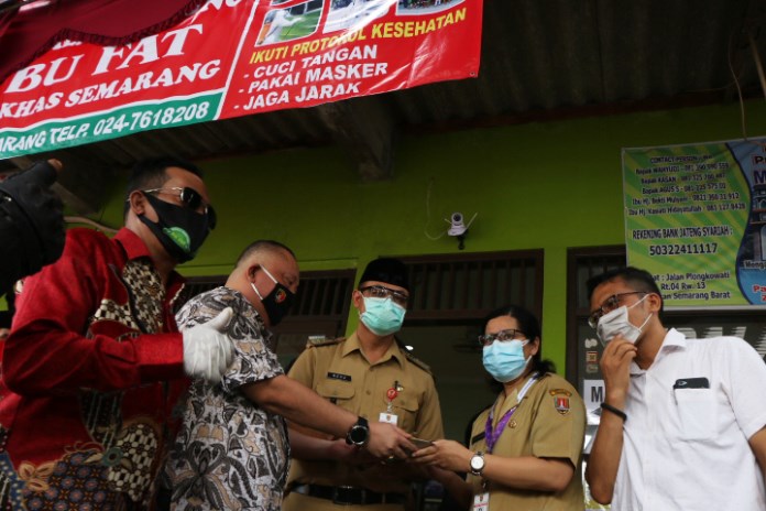 Camat Semarang Barat Heru Sukendar (tengah) saat pembukaan kembali rumah makan kepala manyung Bu Fat Jalan Ariloka. (Nurchamim/Jawa Pos Radar Semarang)