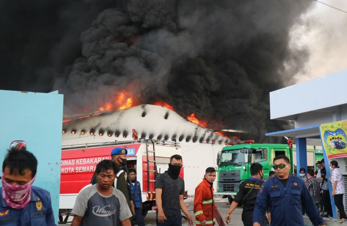 Petugas pemadam dibantu karyawan pabrik mencoba memadamkan gudang Polytron yang terbakar. (Fiani Rosyadan/Jawa Pos Radar Semarang)