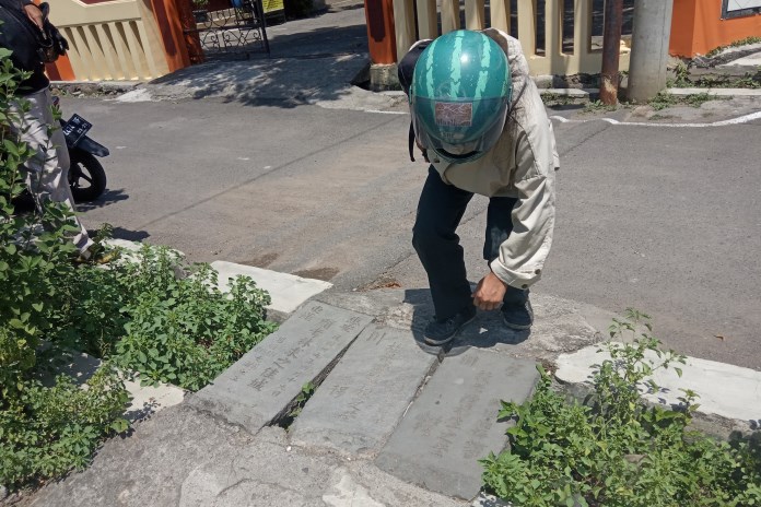 Sebuah bongpay seorang perempuan asal Xihe, Hunan, Tiongkok yang meninggal di Semarang, menjadi penutup selokan di dekat Perumahan Sikluwung Asri, Tandang. (Pratono/Jawa Pos Radar Semarang)