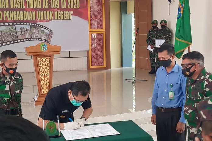 Dansatgas TMMD 109 Letkol Inf Eko Bintara Saktiawan menyaksikan penandatanganan berita hasil TMMD oleh Pjs Bupati Sintang. (Dokumen Kodim 1205 Sintang)