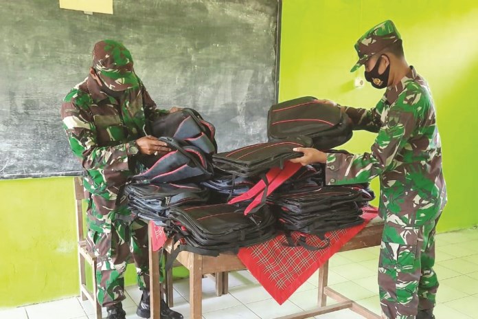 Tim Satgas TMMD Kodim 0715 Kendal memberikan tas kepada siswa-siswi di SDN 04 Sendang Kulon. (Budi Setiyawan/Jawa Pos Radar Semarang)