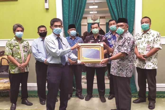 Bupati Demak HM Natsir didampingi Sekda dr Singgih Setyono dan para asisten menerima piagam penghargaan dari Kementerian Keuangan atas opini WTP di pendopo. (Wahib Pribadi/Jawa Pos Radar Semarang)