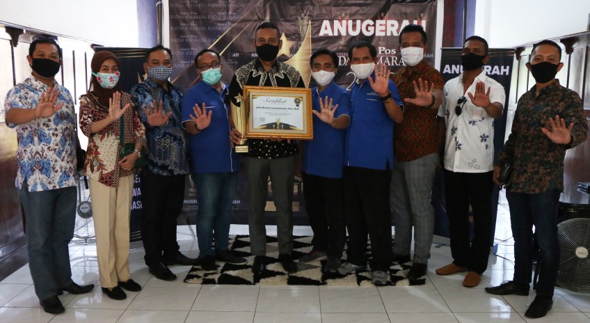 Ketua Komnas Perlindungan Anak Indonesia (KPAI) Kota Semarang John Richard Latuihamallo, SH, MH (pegang piala) berfoto bersama dengan Direktur Jawa Pos Radar Semarang Baehaqi dan jajarannya serta pengurus KPAI Kota Semarang lainnya. (Nurchamim/Jawa Pos Ra