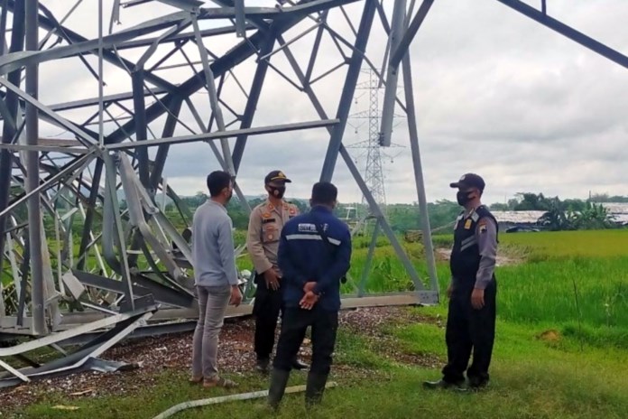 Beberapa petugas Polsek Tersono dan warga melihat kondisi robohnya tower SUTET di area persawahan Desa Kebumen, Kecamatan Tersono. (Istimewa)