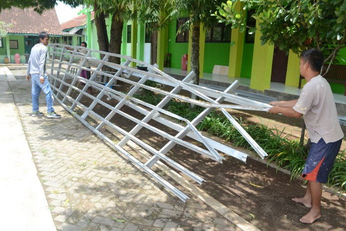 Pekerja mengevakuasi reruntuhan atap teras SMP Negeri 23 Semarang yang roboh. (Nur Wahidi/Jawa Pos Radar Semarang)