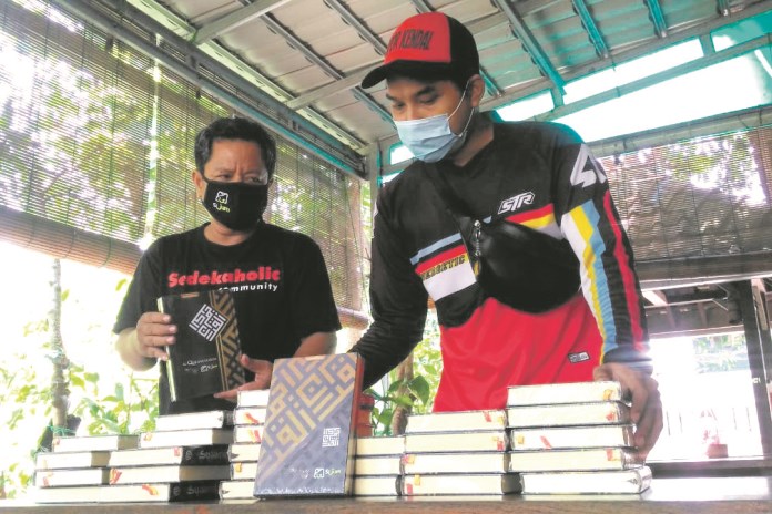 Relawan Sijum Komunitas Sedekaholic Kendal mewakafkan Alquran ke sejumlah masjid dan musala di Kendal. (Budi Setiyawan/Jawa Pos Radar Semarang)