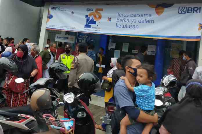 BANTUAN PRESIDEN: Warga antre mengumpulkan formulir penerimaan bantuan BPUM di BRI Demak, kemarin. (wahibpribadi)