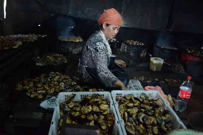 Salah seorang warga Kelurahan Bandarharjo sedang memproduksi ikan asap yang banyak dicari masyarakat. (NURWAHIDI/JAWA POS RADAR SEMARANG)