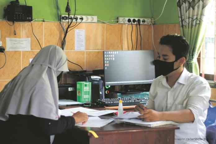 Seorang calon pengantin sedang mendaftarkan rencana pernikahan di KUA Tembalang, Selasa (12/1/2021). (AMELIA NURAINI PURNOMO/JAWA POS RADAR SEMARANG)