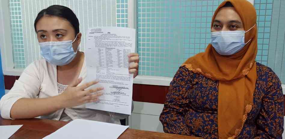 Natalia Suhendrik menunjukkan surat perintah penangkapan terhadap ibunya yang dikeluarkan Kapolsek Semarang Utara. (M HARIYANTO/JAWA POS RADAR SEMARANG)