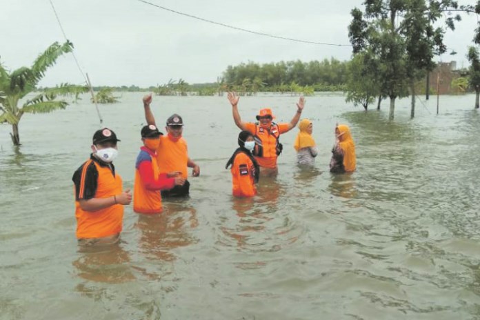 Sejumlah petugas saat berada di wilayah banjir Kecamatan Sayung. (Wahib Pribadi/Jawa Pos Radar Semarang)