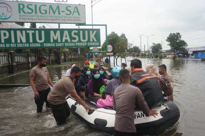 Warga menerjang banjir yang merendam Jalan Kaligawe Raya, kemarin. Banjir di kawasan ini menutup akses menuju RSI Sultan Agung. (ADITYO DWI/JAWA POS RADAR SEMARANG)