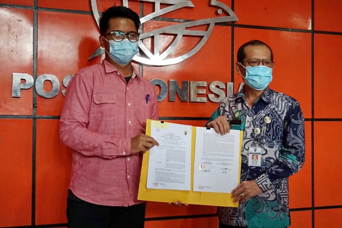 Kepala Dindukcapil Kota Pekalongan Suciono menunjukkan surat kerjasama dengan PT Pos Kota Pekalongan Selasa (16/2/2021). (Lutfi Hanafi/Jawa Pos Radar Semarang)