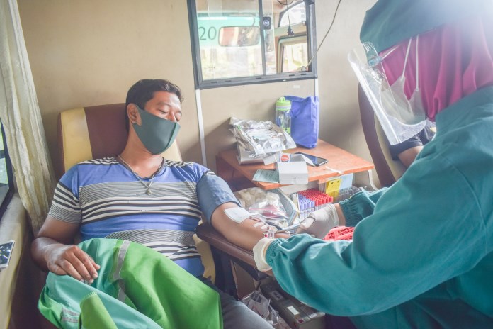 Seorang warga mendonorkan darahnya di bus donor keliling yang berhenti di Jalan Prof Soedarto Rabu (24/2/2021). (TITIS ANIS FAUZIYAH/JAWA POS RADAR SEMARANG)
