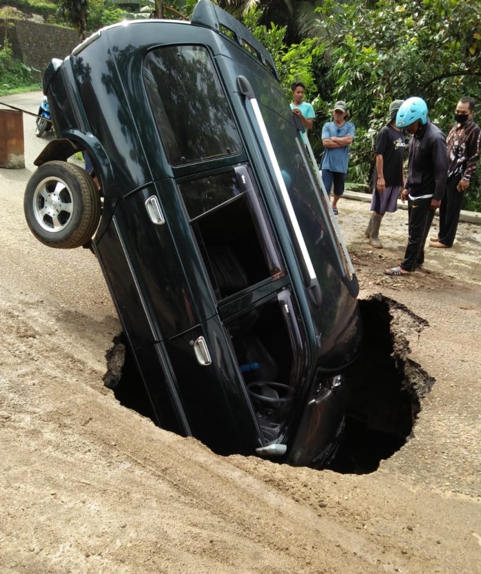 Mobil Toyota Kijang LX nopol AA 8583 VF yang dikemudikan Andi Asmara, 31, terperosok ke lubang sedalam sekitar dua meter di Dusun Pengempon, Desa Kemiriombo, Kecamatan Kaliwiro, Wonosobo. (SIGIT RAHMANTO/JAWA POS RADAR SEMARANG)