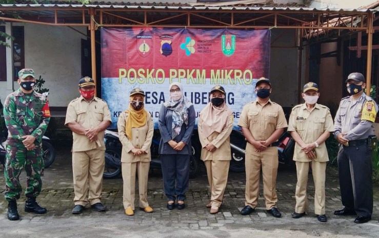 Perangkat Desa Kalibening beserta aparat keamanan di desanya foto di posko PPKM Mikro. (LUQMAN SULISTIYAWAN /JAWA POS RADAR SEMARANG)