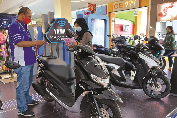 Seorang pengunjung Artos Mall mampir ke stan Sumber Baru Motor (SMB) Magelang untuk mencari informasi harga sepeda motor. (PUPUT PUSPITASARI/JAWA POS RADAR SEMARANG)