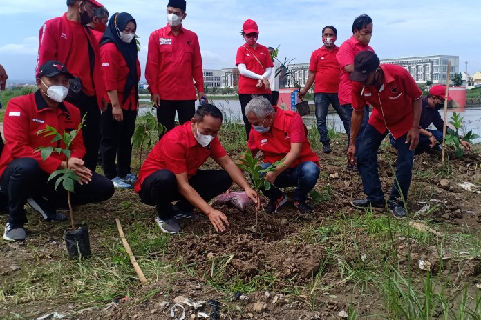 Pengurus DPC PDIP Kota Semarang ketika melakukan penghijauan tahap kedua di Banjir Kanal Barat, Minggu (21/2/2021). (ADENNYAR WYCAKSONO/JAWA POS RADAR SEMARANG)