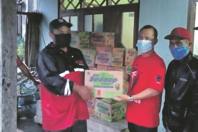 Ketua DPC PDIP Demak, Fahrudin Bisri Slamet menyerahkan bantuan logistik kepada warga Sayung. (Wahib Pribadi/Jawa Pos Radar Semarang)
