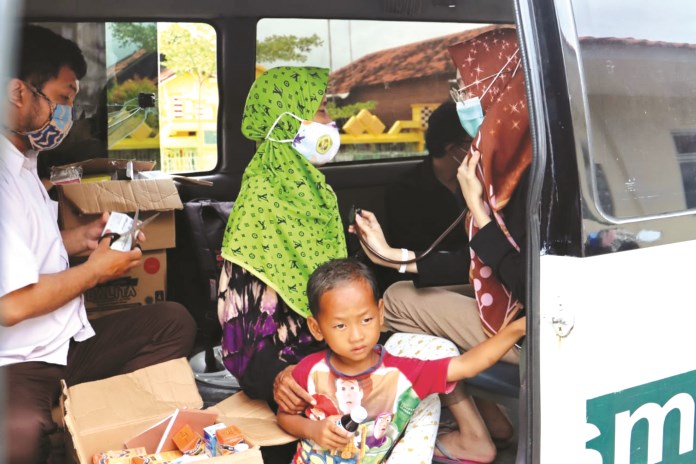 Petugas Dinkes Kota Pekalongan memeriksa kesehatan pengungsi, termasuk untuk mencegah penyebaran Covid-19. (Lutfi Hanafi/Jawa Pos Radar Semarang)