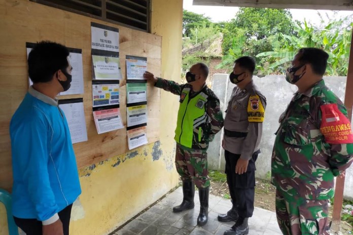 Danramil Mranggen Kapten Sukartiyo mengecek posko PPKM skala mikro di Mranggen. (Wahib Pribadi/Jawa Pos Radar Semarang)