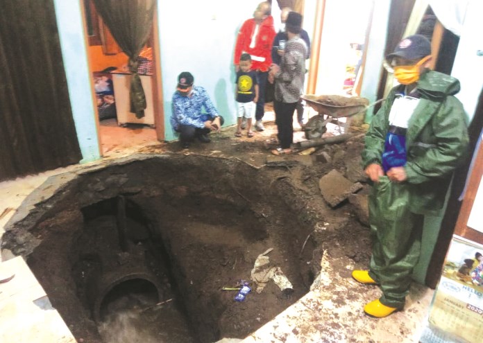 Lubang besar di ruang tamu rumah milik Supadiyono gara-gara saluran air di bawahnya mampet dan ambrol. (Istimewa)