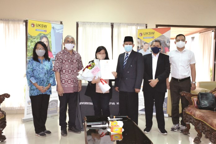 Prof Listyani (bawa bunga) menjadi perempuan kedua di UKSW yang menyandang gelar guru besar. (Dhinar Sasongko/Jawa Pos Radar Semarang)