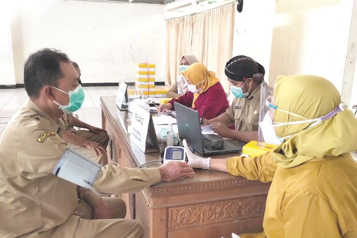 Vaksinasi tahap kedua pada hari pertama digelar di GOR Gemilang Magelang, Selasa (23/2/2021). (RIRI RAHAYUNINGSIH/JAWA POS RADAR SEMARANG)