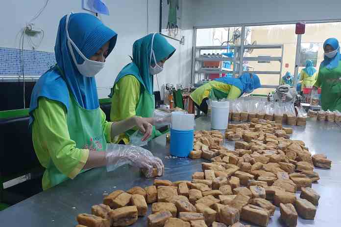 Sejumlah pekerja mengemasi tahu bakso di pabrik Tahu Baxo Ibu Pudji Ungaran, Kabupaten Semarang, Jumat (12/3/2021). (TITIS ANIS FAUZIYAH/JAWA POS RADAR SEMARANG)