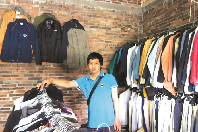 Iyam sedang menata barang dagangannya di Jalan Soekarno-Hatta, Mungkid. (RIRI RAHAYU/JAWA POS RADAR SEMARANG)